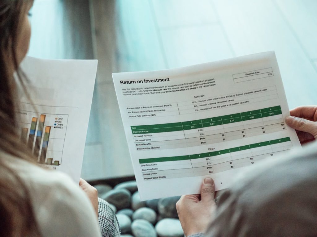 Two people looking at data while determining when to sell a credit card processing portfolio