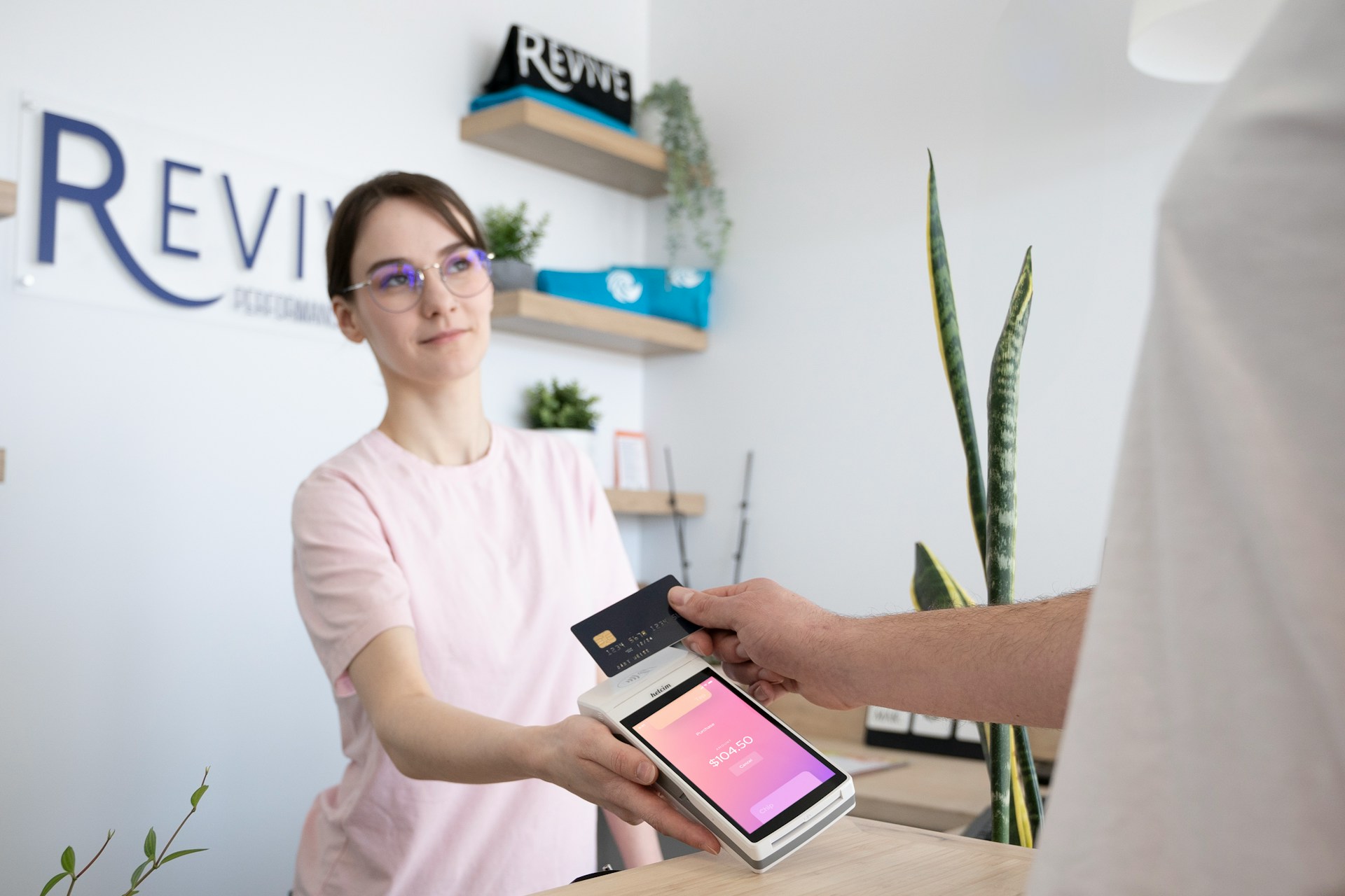 A person asking questions about what a merchant portfolio is as making a payment at a company’s front desk