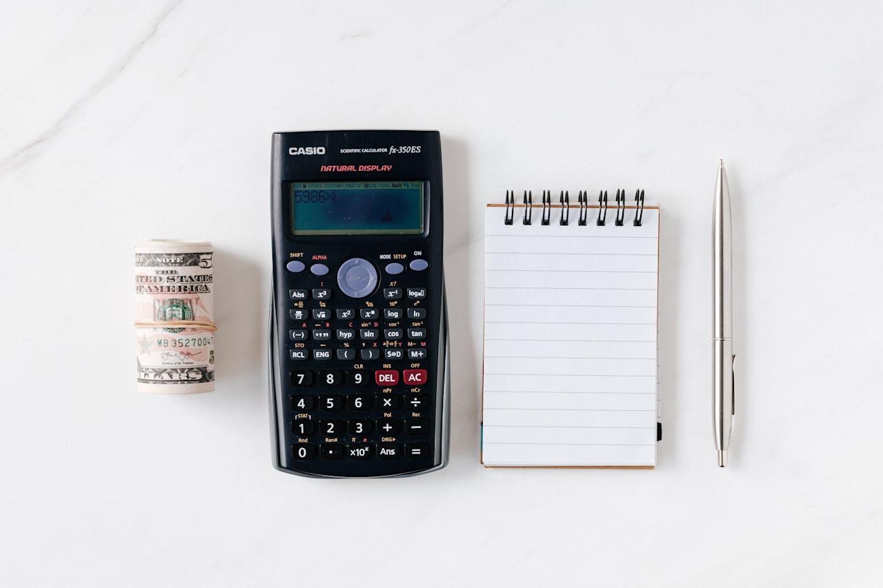 A notepad and calculator on a table used to determine the profit potential of a payment processing portfolio