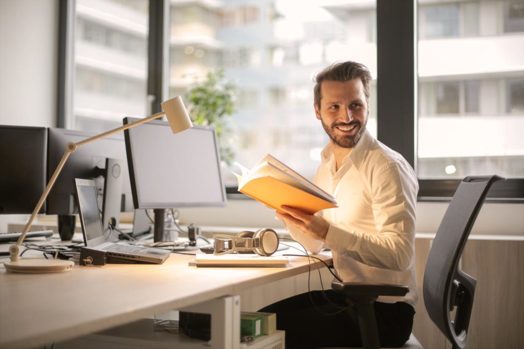 A person smiling at his desk after securing merchant contracts