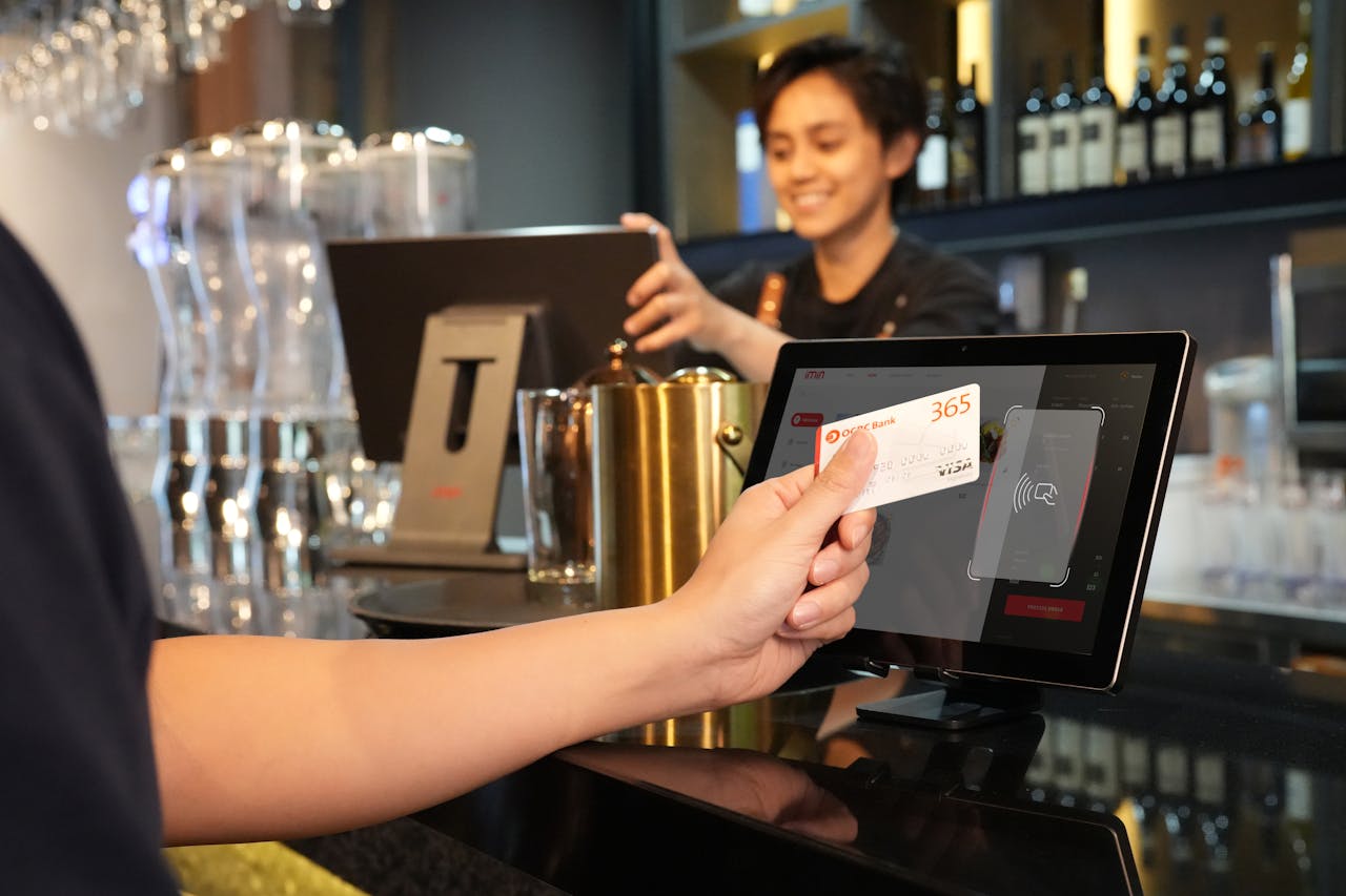 A person making a payment by holding a credit card up to a monitor