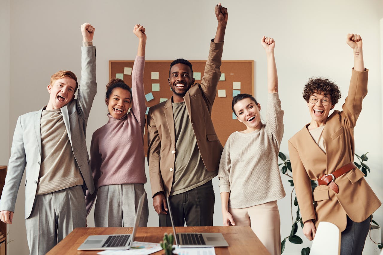 A group of people with their arms raised after segmenting a merchant portfolio