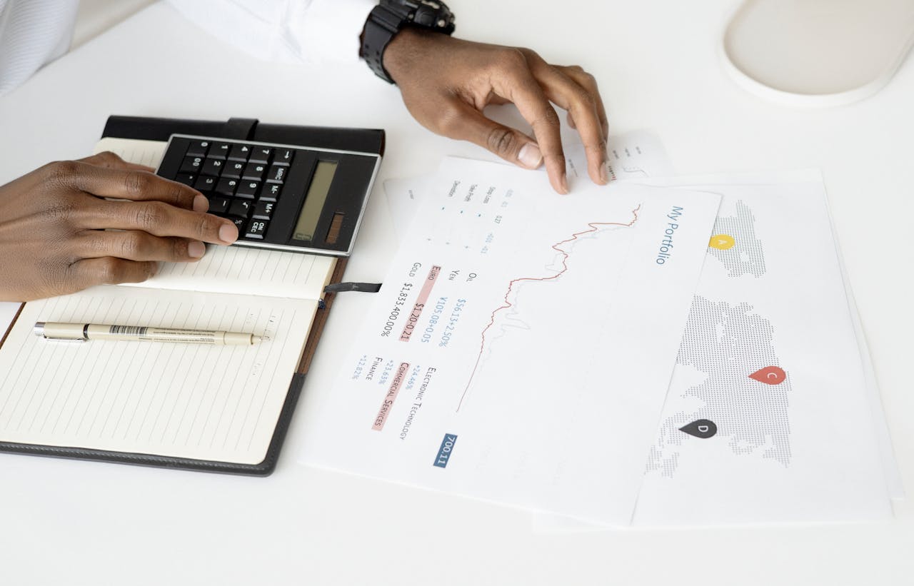A person calculating numbers as factors to consider before selling