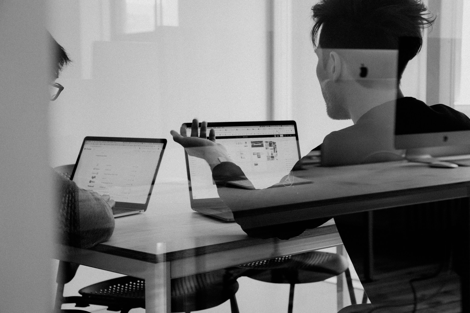 Two people sitting at a table and discussing merchant portfolio expansion strategies