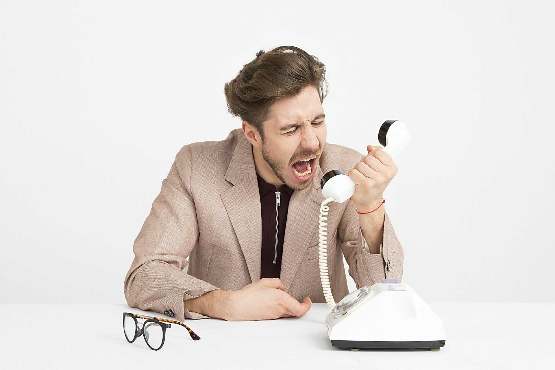 An angry man yelling into a telephone