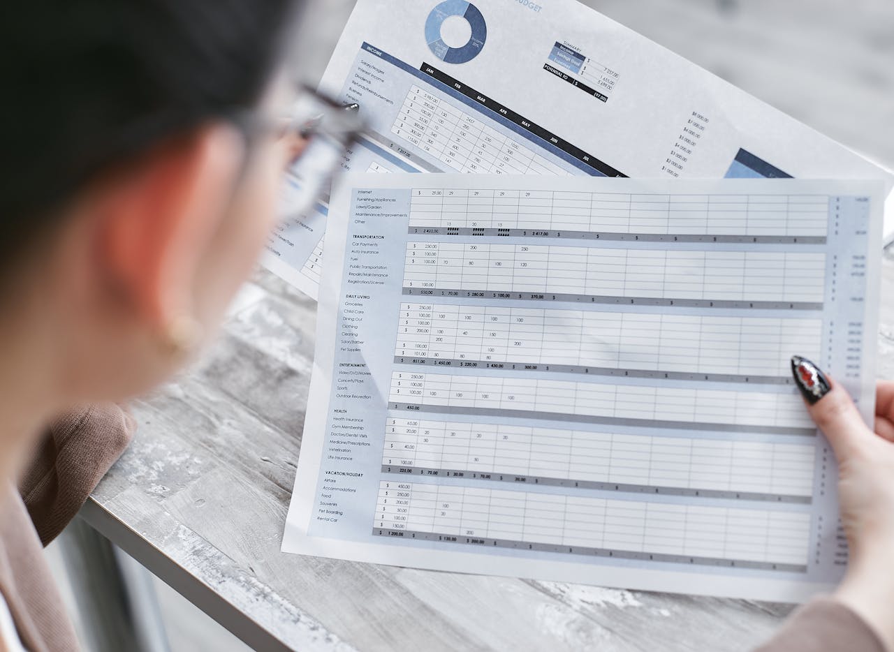 A person holding a print-out of a spreadsheet